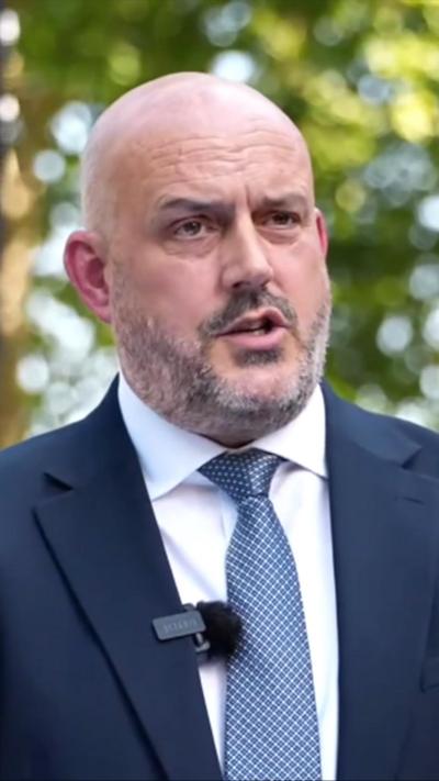 Laurence Taylor in a navy blue suit and tie