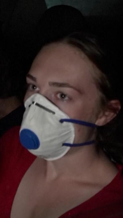 Young woman wears a face mask in her car