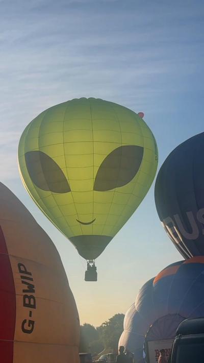 Alien hot air balloon against blue sky