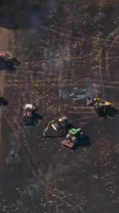 Tractors in a burnt field.