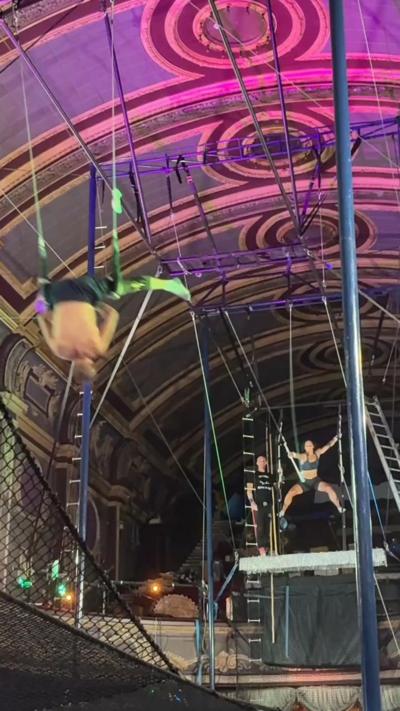Two people flying a trapeze.