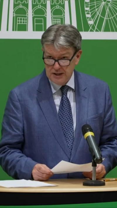 Man in blue suit speaking at podium