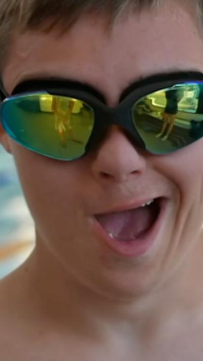 A young man wearing reflective swimming goggles.