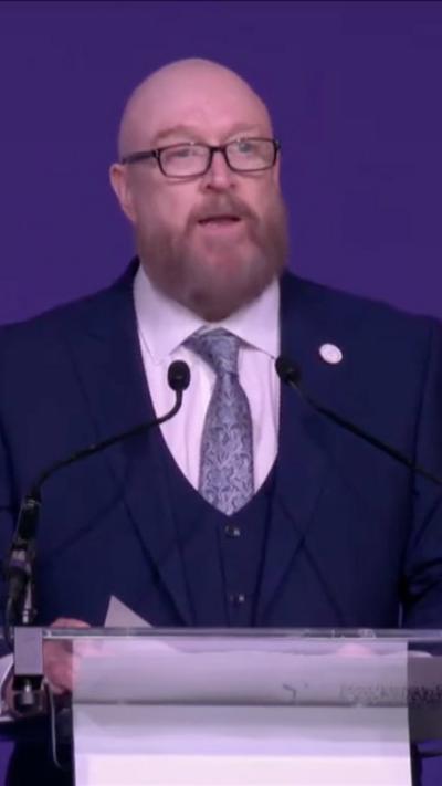 Paul Price stands at a podium