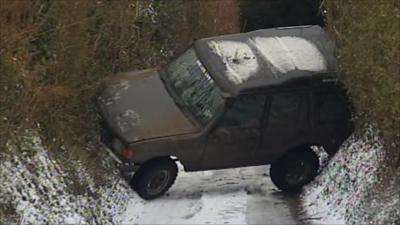 Car wedged between embankments on a country lane