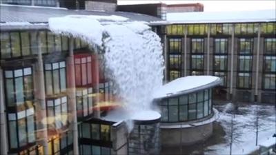 Snow falling from the roof of the Scottish Widows building