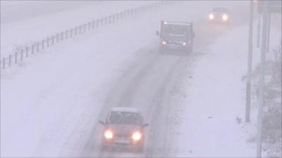 Cars drive through snow on the A465 in Wales