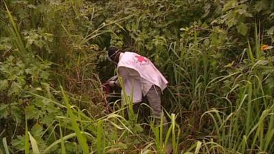 Red Cross worker in long grass
