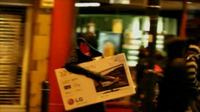 A looter makes off with a TV