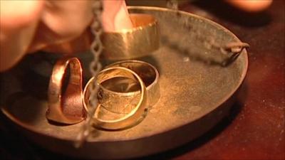 Gold rings being put on scales