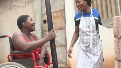 Mariana Tembe (l) and Victoria Massingue (r) laughing as they prepare food together