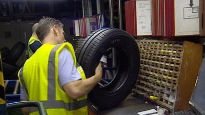 Men checking tyres in a factory