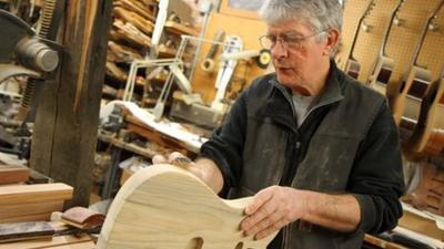 Guitar maker sanding unfinished guitar