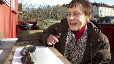 Anne Margrethe Thomassen looks at the meteorite which hit her cottage roof in Oslo