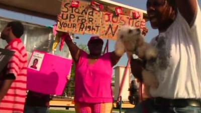 Woman holds up placard that reads "Stand up for your right".