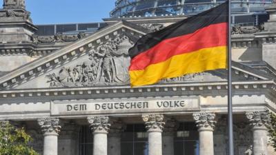 The German flag flying in front of the Reichstag
