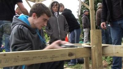 Young person sawing wood