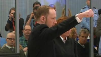 Anders Breivik makes a salute in court