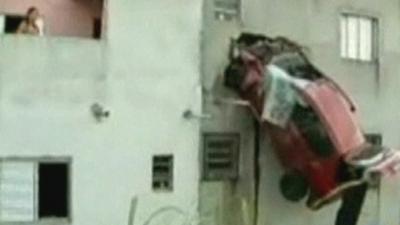 Car stuck on side of building