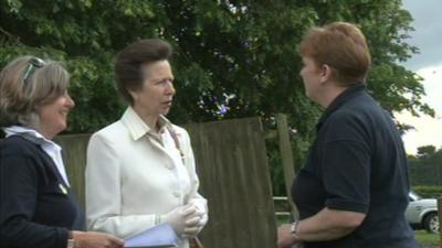 Princess Anne speaking to volunteers at the riding school