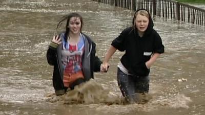 Girls wade through deep water