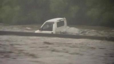 Van swept along in flood waters
