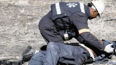 An injured policeman is attended to after he was attacked and injured by striking Lonmin miners near Rustenburg.