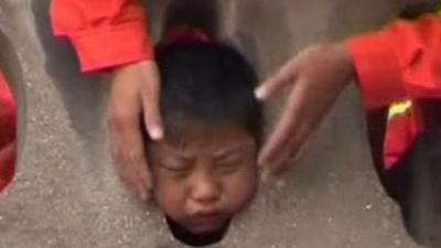 The boy with his head stuck between two stone pillars