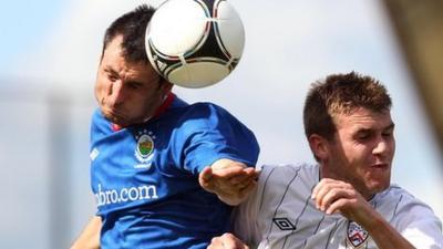 Linfield's Jim Ervin beats Coleraine's Stephen Lowry to the ball