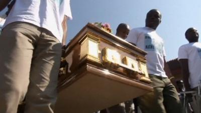 Men carry coffin