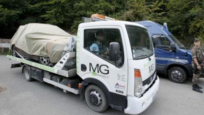 Truck carrying away covered BMW
