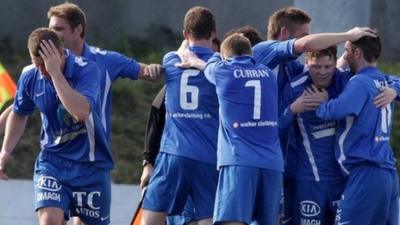 Ballinamallard players celebrate the late winner against Cliftonville