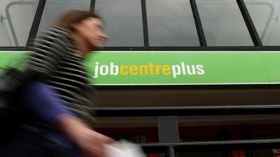 A woman walking past a Job Centre Plus