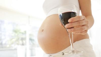 Pregnant lady holding wine glass