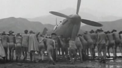 Men push spitfire along ground