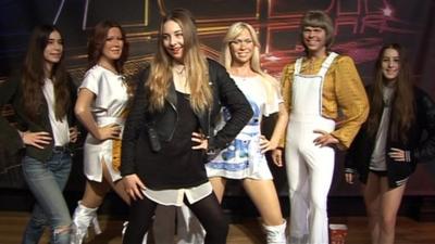 Danielle (L) , Este (C) and Alana Haim stand with Abba waxworks