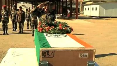 Coffin of Indian soldier being saluted