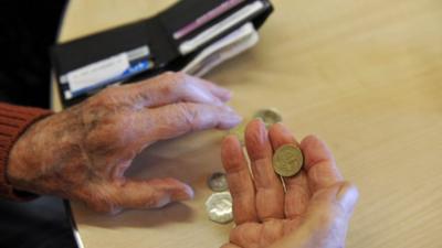 Elderly person holds money