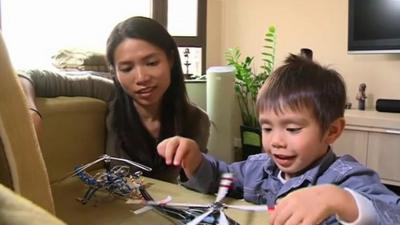 Mother watching her son playing with toy aircraft