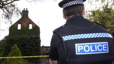 Police officer standing outside a derelict building