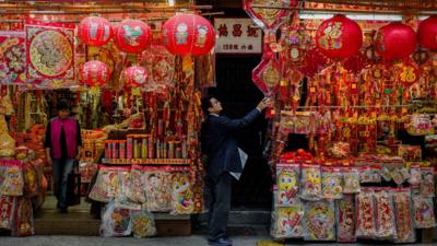 A man takes a look at a display of Chinese New Year decorations in Hong Kong