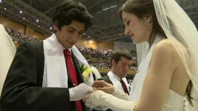 Couple exchanging rings in mass wedding