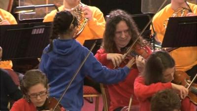 Deaf child touching violin