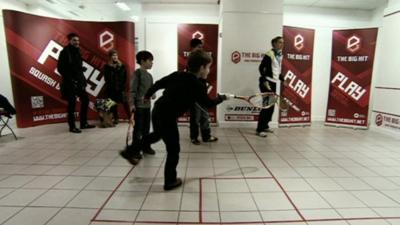 Child plays squash inside a converted shop