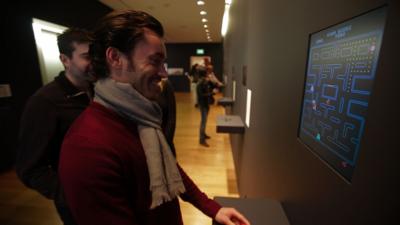 Man watches PacMan at the MoMA