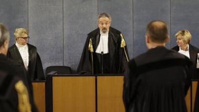 Court president Oscar Magi, center, reads sentence