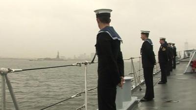 The crew of HMS Edinburgh on deck, with the Statue of Liberty visible in the distance