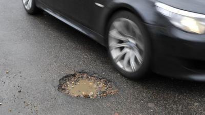 A car passing a pothole