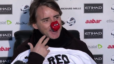 Manchester City manager Roberto Mancini wearing a red nose for Comic Relief