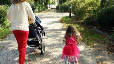 Mother and her three-year-old daughter walk together